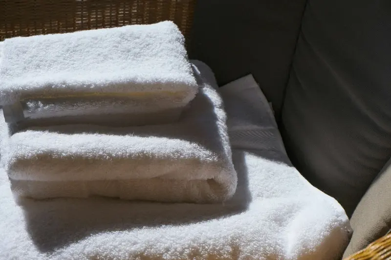 Pile de serviettes de bain blanches épaisses pliées, lumière chaude et douce