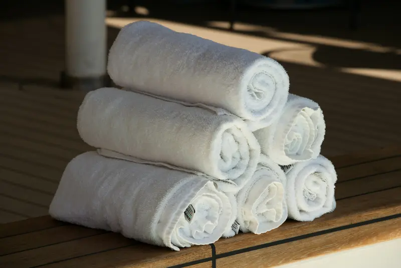 Serviettes de bain blanches roulées et empilées en pyramide, ambiance spa